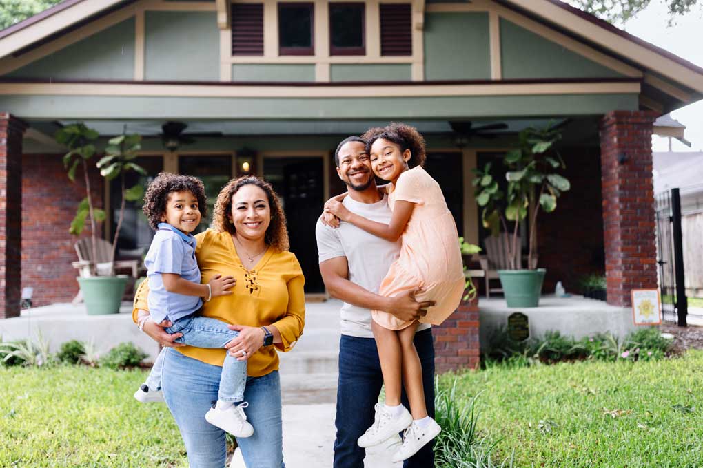 Family standing in front of their home