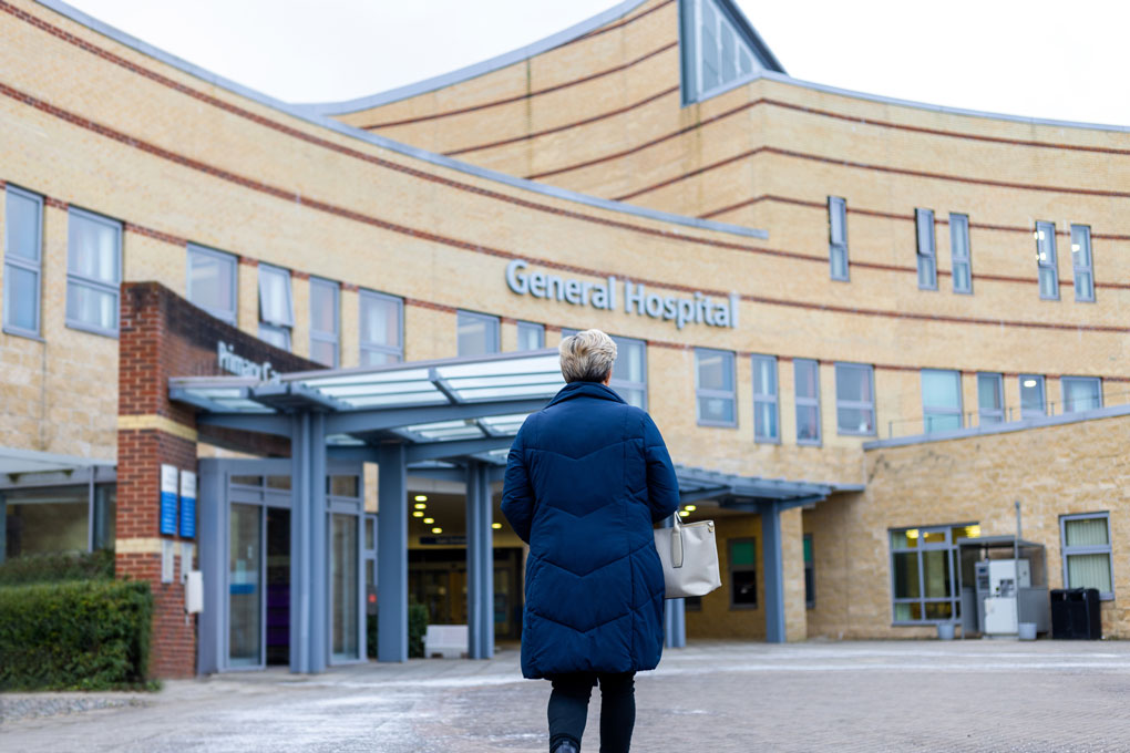 Patient approaches exterior of hospital